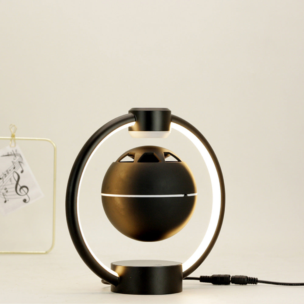 Black magnetic levitation Bluetooth speaker with circular LED light and modern design for wireless home audio.